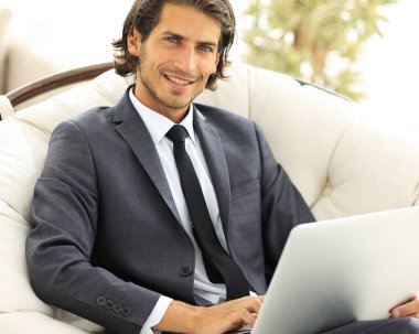 işadamı bir şık rahat chai oturan bir dizüstü bilgisayar ile