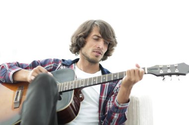 Yakışıklı adam evde kanepede gitar çalmaya