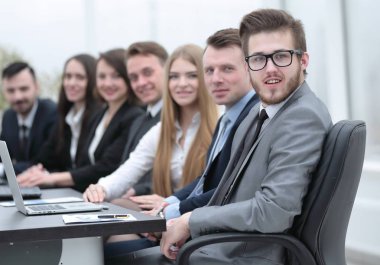 İş ekibi konferans odasındaki masada oturuyor.