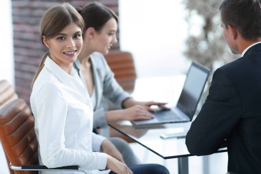 bir masanın arkasında oturan Ofis çalışanları.