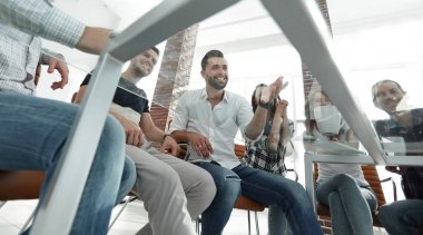 bir masanın arkasında oturan çalışanlar