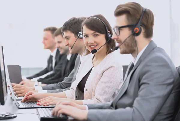 Call center operador com colegas sentados no local de trabalho — Fotografia de Stock