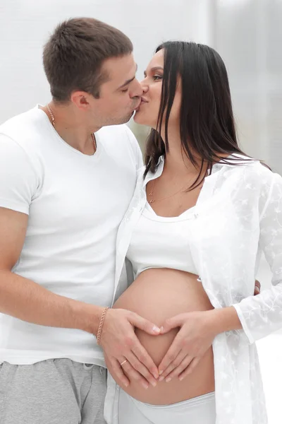 Suami dan istri hamil dengan tangan terlipat dalam bentuk hati di perutnya — Stok Foto