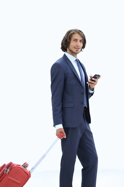 Homem de negócios bonito com bagagem digitando SMS no smartphone — Fotografia de Stock