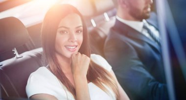 Arka koltukta arabasındaki beyaz elbiseli bir kadın portresi