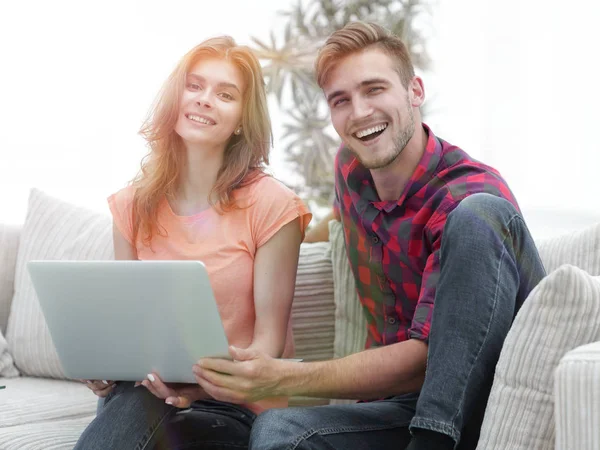 Sorrindo casal descansando em casa, sentado no sofá . — Fotografia de Stock