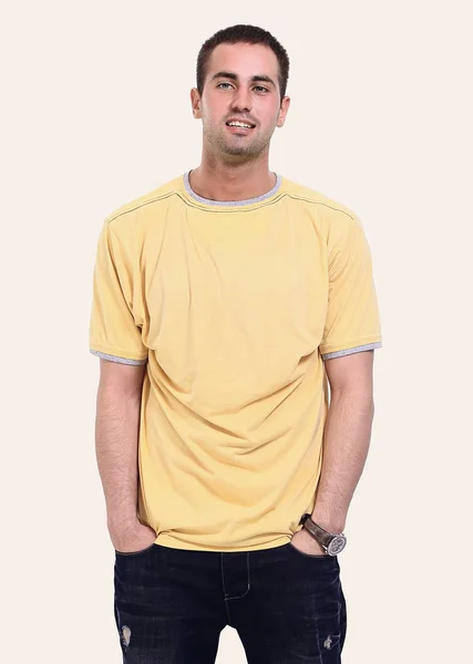 Young man in a yellow t-shirt and jeans. — Stock Photo, Image