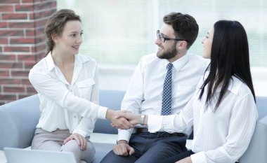 Ofis lobisinde yönetici ve müşterinin el sıkışması.