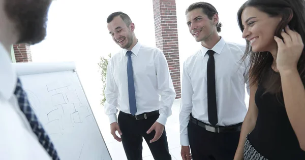 Hombre de negocios apuntando equipo de negocios en un rotafolio en blanco . — Foto de Stock