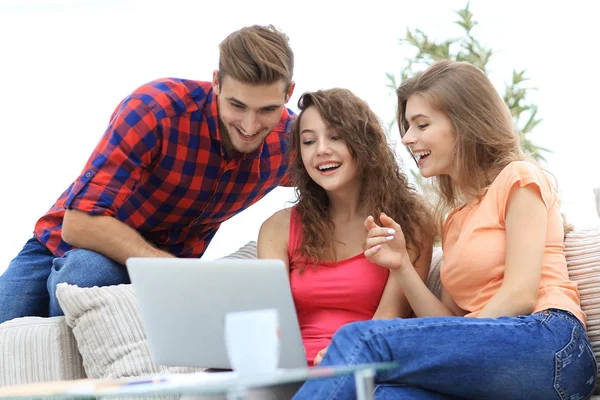 Groupe d'étudiants regardant un écran d'ordinateur portable, assis sur le canapé — Photo