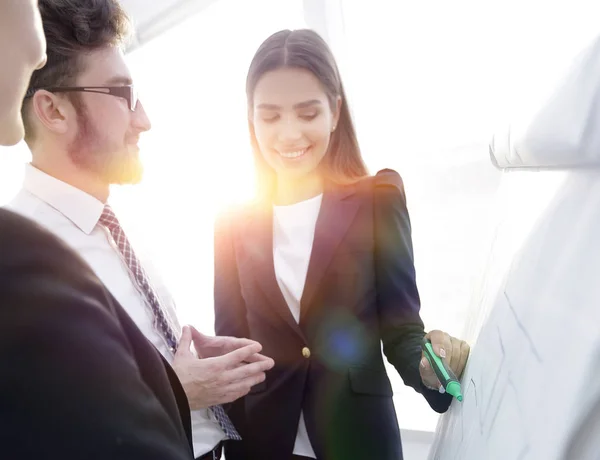 Business woman pointing with a marker on the flipchart — Stock Photo, Image