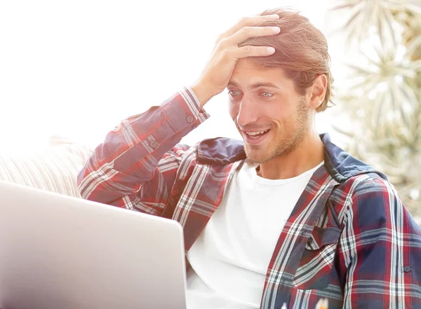 Meglepett fiatal ember dolgozik a laptop otthon. — Stock Fotó
