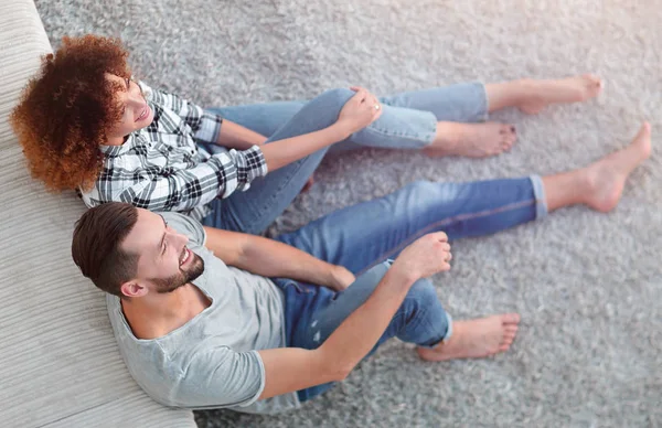 yeni bir oturma odasında bir halı üzerinde oturan yeni evli çift