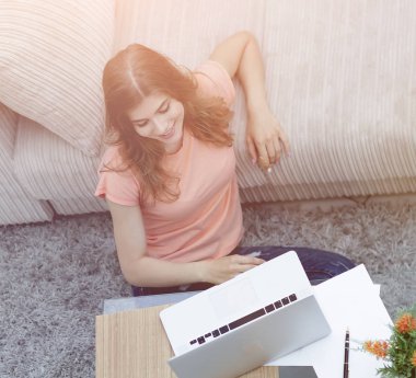 kız öğrenci halı üzerinde oturan dizüstü bilgisayar üzerinde çalışan bu yüzden