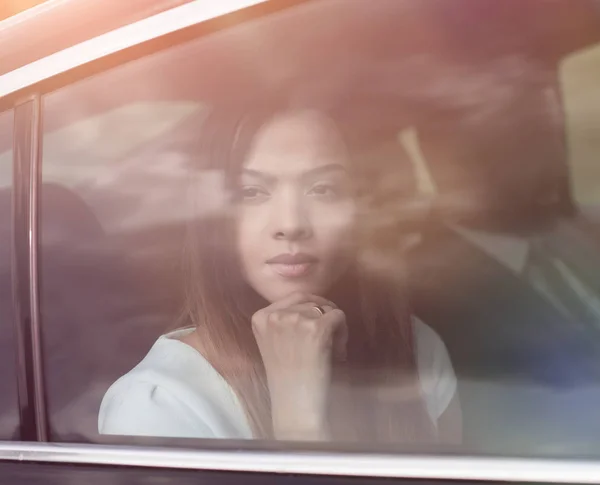 Mujer de negocios pensativo sentado en el asiento trasero del coche — Foto de Stock