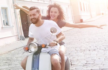 mutlu genç bir çift bir scooter üzerinde eğleniyor