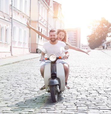 mutlu genç bir çift bir scooter üzerinde eğleniyor