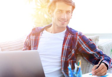 Kendine güvenen adam evde laptop ile çalışma.