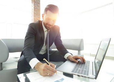 Dizüstü bilgisayarda çalışan ve Notlar not defterinde yapma şık adam