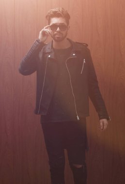 Siyah deri ceketli ve kot pantolonlu bir adam