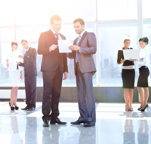 Employees discuss working paper standing in the lobby of the off — Stock Photo, Image