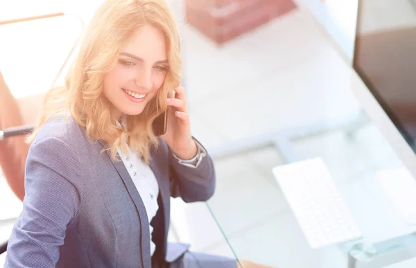 Exitosa joven mujer de negocios sentada en un escritorio —  Fotos de Stock