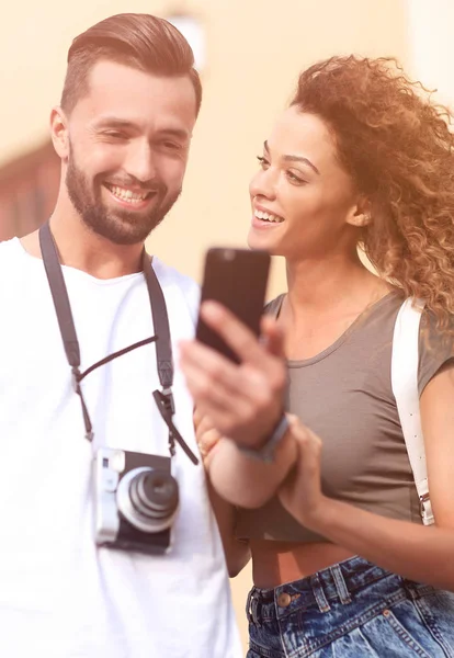 Щаслива молода пара шукає місце розташування як на мобільному телефоні — стокове фото