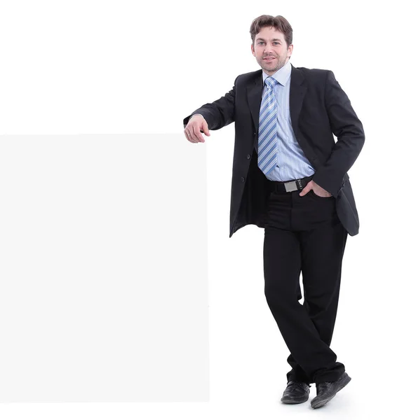 Businessman leaning on a blank poster. — Stock Photo, Image