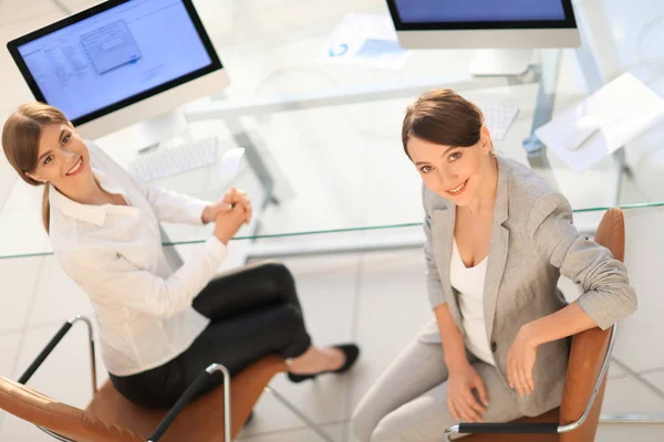 View from the top. two women colleagues sitting near the desktop — Stock Photo, Image