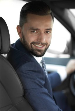 Kameraya bakarak bir arabanın ön koltuğunda otururken yakışıklı genç