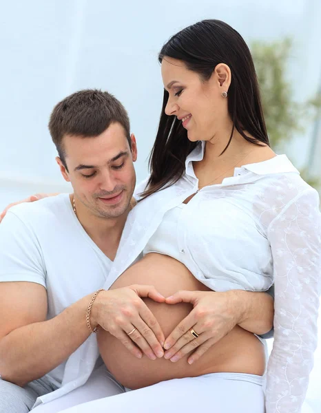 Closeup .husband e mulher grávida colocando as mãos em sua barriga . — Fotografia de Stock