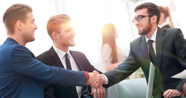 Socios concluyendo trato y estrechando la mano en presencia de los miembros del equipo —  Fotos de Stock