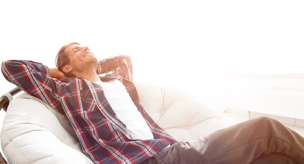 Moderne man rust in een grote comfortabele stoel zitten. Zijaanzicht. — Stockfoto