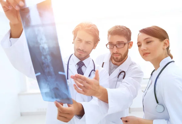 Tre säkra läkare undersöka en röntgenbild — Stockfoto