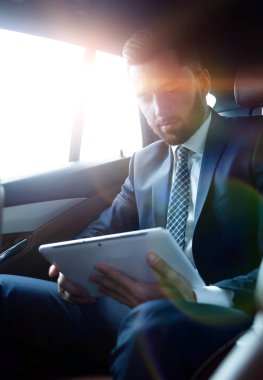 işadamı arka koltuğunda oturan bir dijital tablet ile bir 