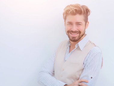 Bir adam beyaz gömleğin yakasını düzeltir.