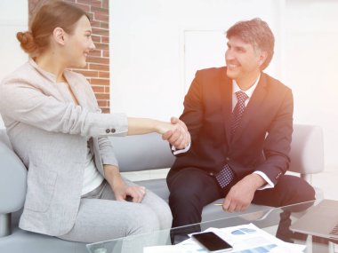 İş adamları iş yerinde otururken el sıkışıyor