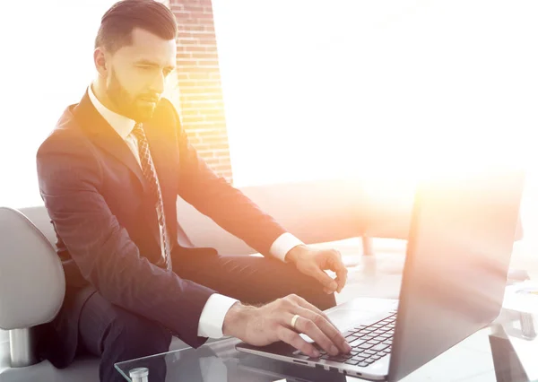 Homme d'affaires travaillant sur ordinateur portable assis dans le hall du bureau — Photo