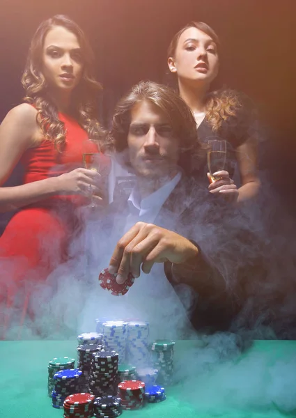 Fortunate gambler surrounded by seductive elegant women — Stock Photo, Image