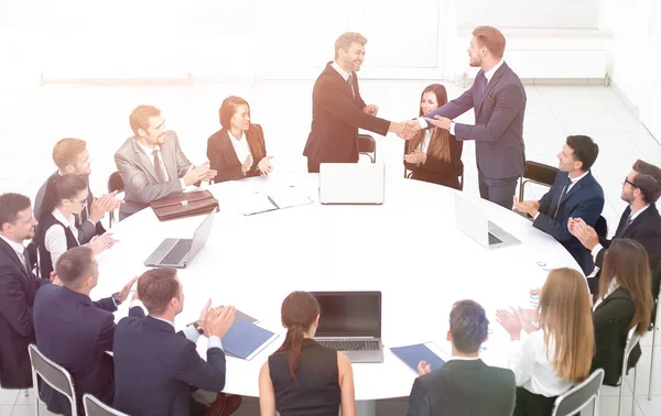 Partnerzy biznesowi uścisnąć dłoń podczas rozmów w pobliżu okrągłego stołu — Zdjęcie stockowe