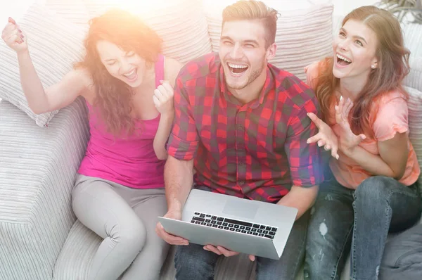 Groep vrienden kijken naar een video op een laptop en lachen — Stockfoto