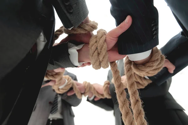 closeup.business team holding rope forming a circle