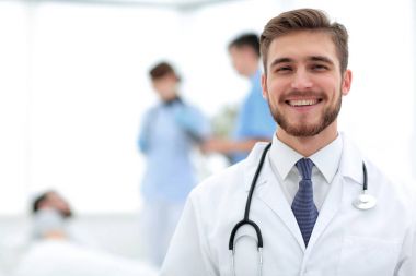 Doktor bulanık arka plan üzerinde gülümseyen