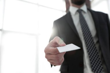 Parlak arka plan üzerinde kartvizit vererek iş adamı