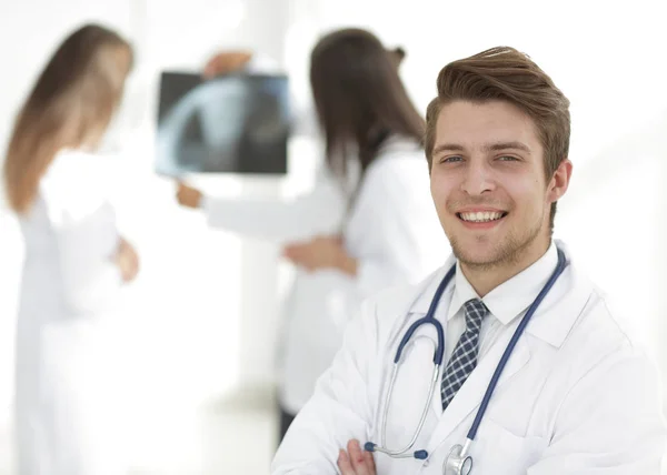 Joven doctor en el fondo de colegas —  Fotos de Stock