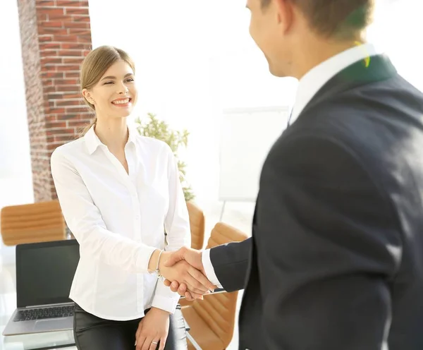 Woman Manager vítá klienta stiskem ruky. — Stock fotografie