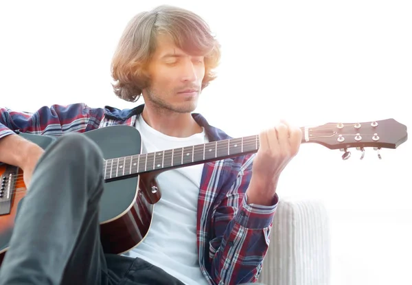 Bonito homem tocando na guitarra no sofá em casa — Fotografia de Stock