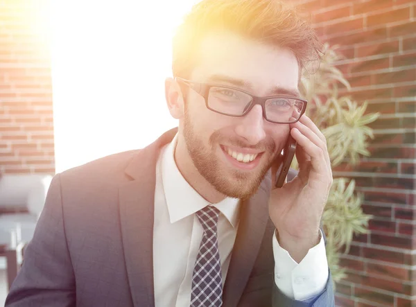 Homem de negócios falando no telefone inteligente no escritório moderno — Fotografia de Stock