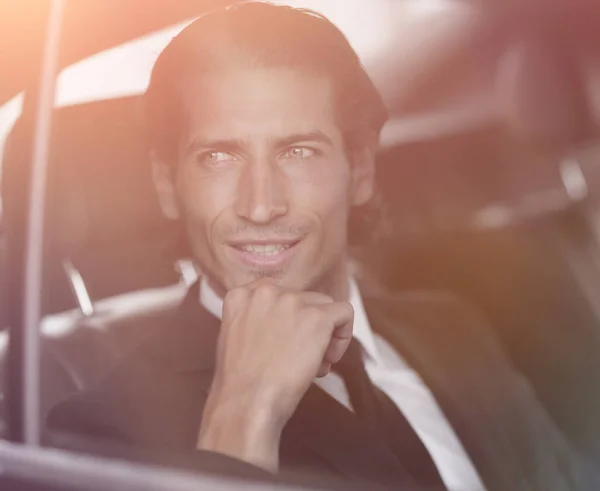 Primo piano. Uomo d'affari di successo seduto in macchina — Foto Stock