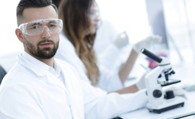 mikrobiyolog ve meslektaşları modern bir laboratuarda oturuyor